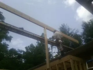 Carpenter setting a ridge beam over a new addition frame — Ice Dam Removal by Roofing Brothers in Grain Valley