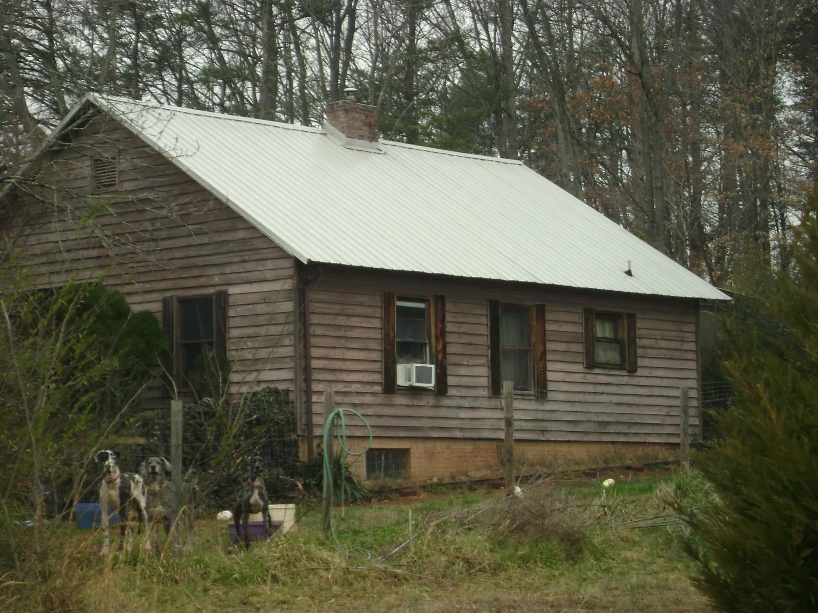 White metal roof on an old wood sided farmhouse, from a Metal Roof Installation job in Grain Valley
